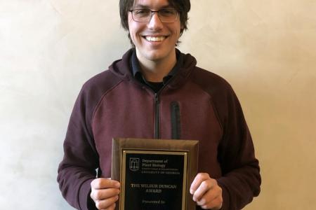 Bill Ricci posing with Wilbur Duncan Award plaque - 2019
