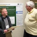 A student and professor discussing the student's research poster