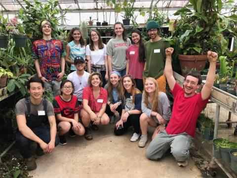 Group of undergraduate students gathered at a greenhouse.