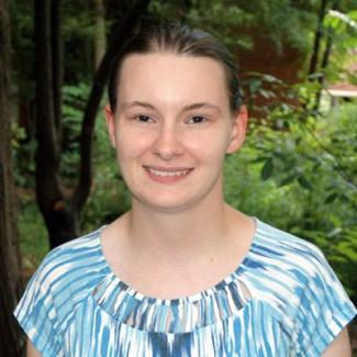 close-up headshot photo of Ashley Earley with background of greenery