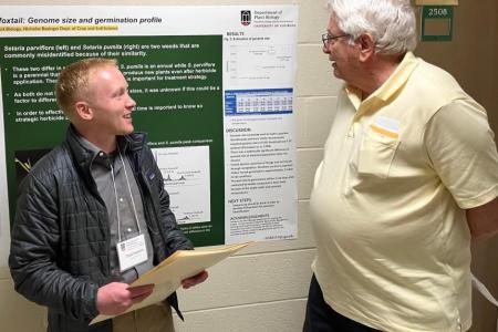 A student and professor discussing the student's research poster